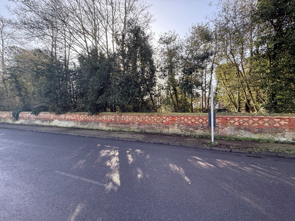 Lot: 112 - OVER HALF AN ACRE OF FREEHOLD PARCEL OF LAND - Wider shot of wall